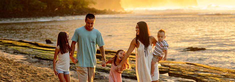 family enjoying sunset at Kauai beach